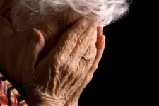 Old person holding hands on her face. Photo. 