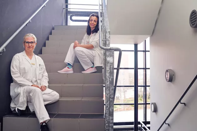 Åsa Petersén och professor i neurovetenskap och postdoktor Sanaz Gabery sittandes på behörigt corona-avstånd i trapphuset på biomedicinskt centrum i Lund. 